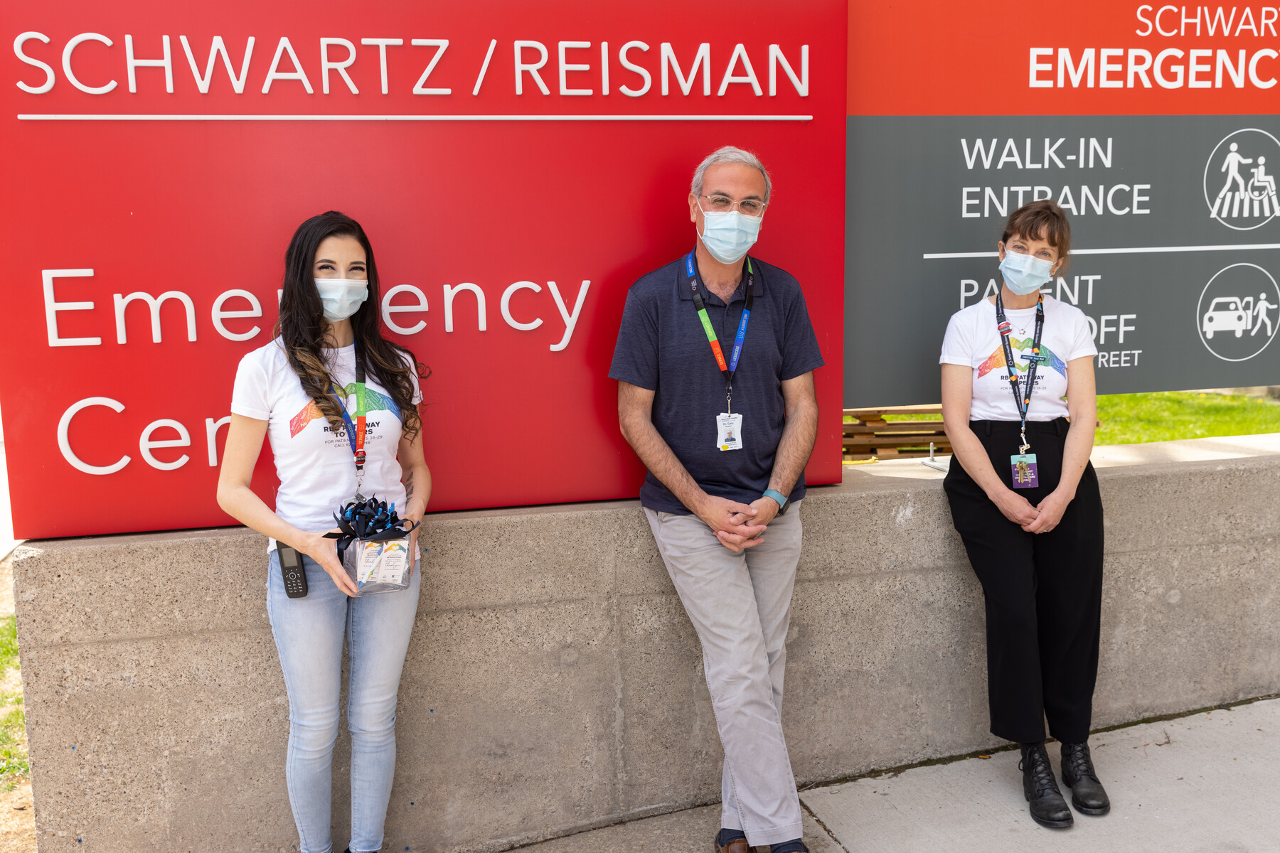 Yolanda Delmonte, Gary Newton and Christine Bradshaw standing outside the Schwartz/Reisman Emergency Centre sign with masks on