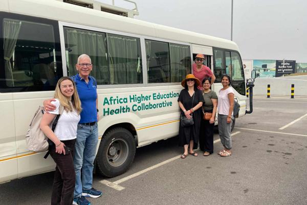 Dr. Melady in front of the Africa Higher Education Health Collaborative vehicle